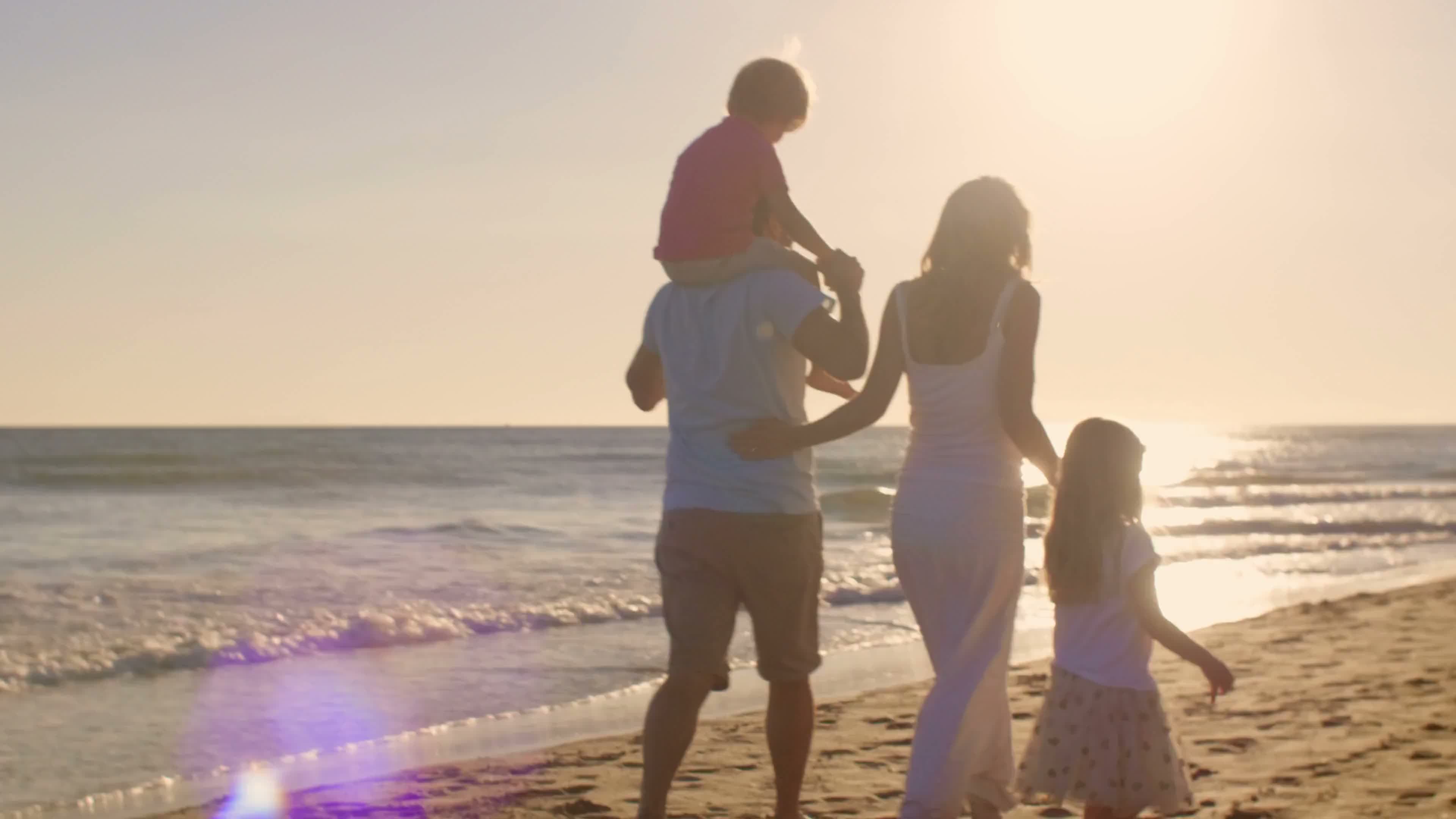 Family walking along the beach near Long Branch at sunset