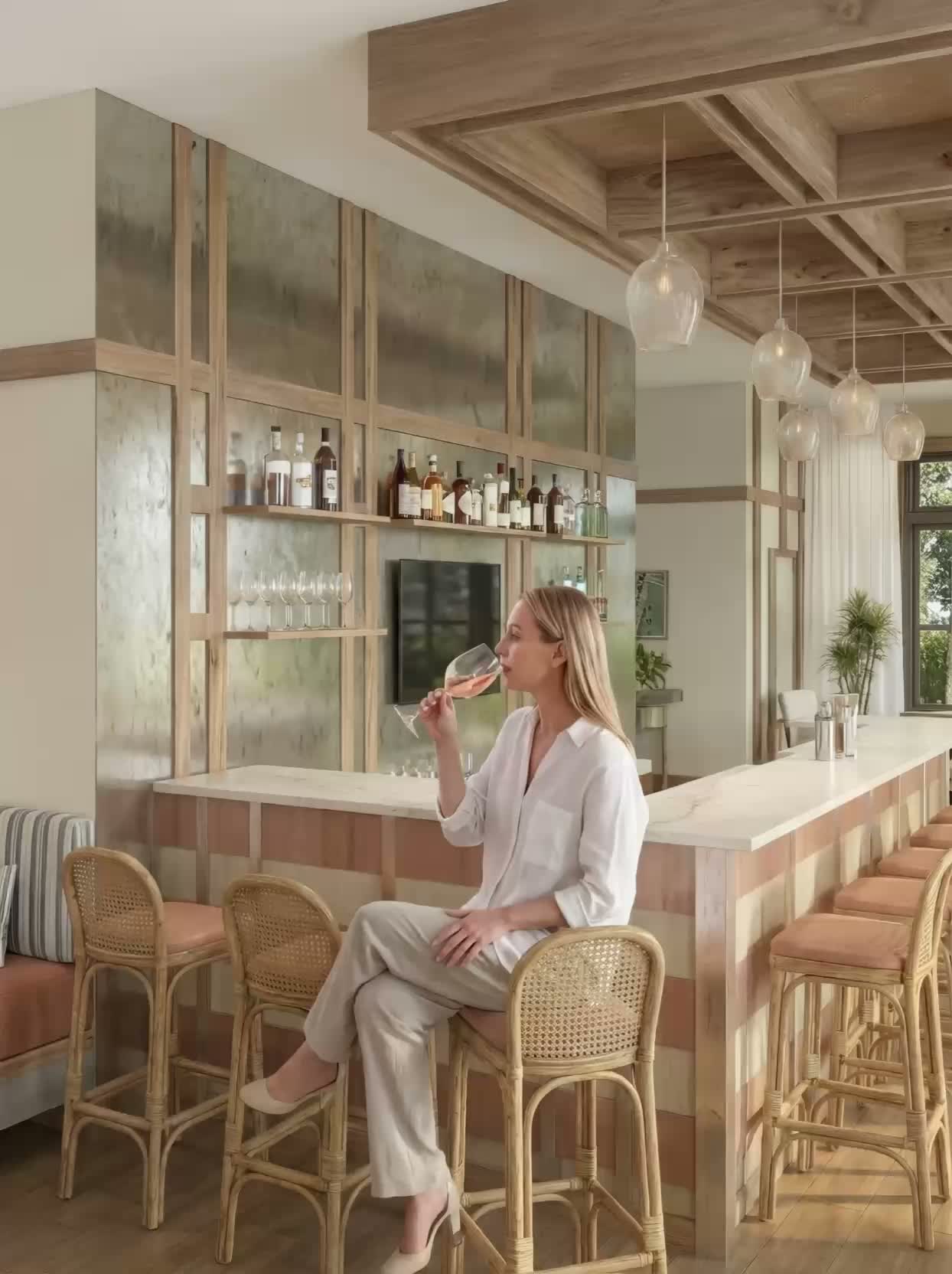 Woman seated at the Liora amenity bar with a glass of wine