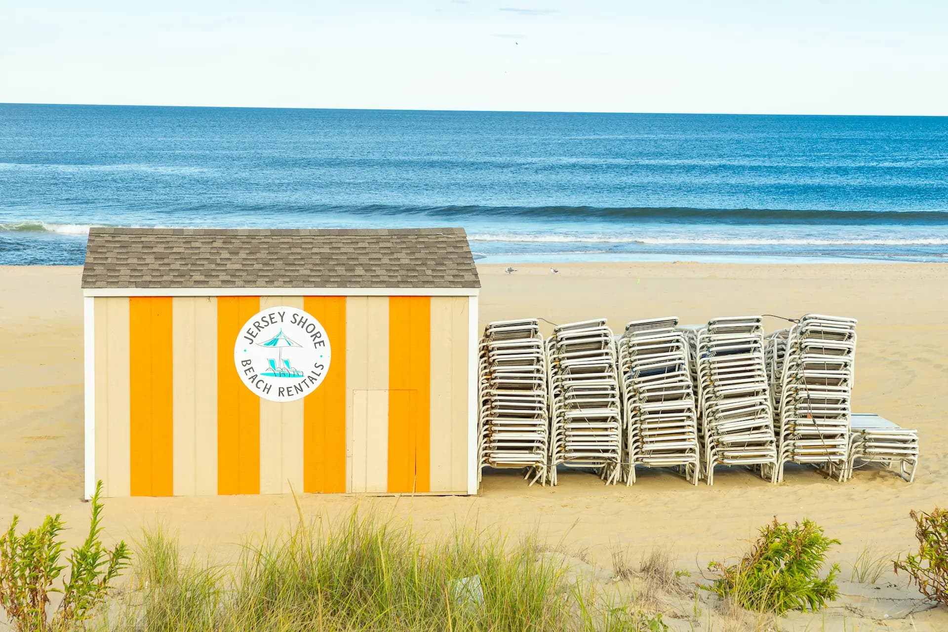 Jersey Shore beach rental stand with stacked lounge chairs by the ocean | Offsite Photography